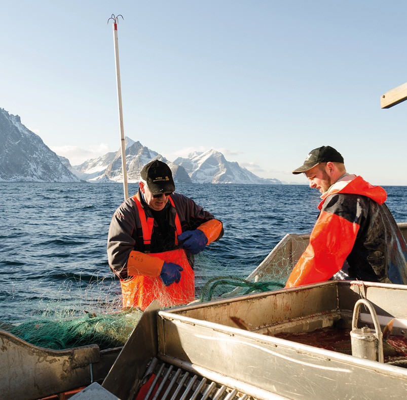 To menn på fiskebåt på sjøen
