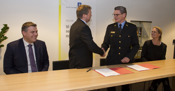 Magne Kongsvik i Airlift og Knut Smedsrud i Politidirektoratet trykker hender etter å ha signert avtalen. De er flankert av justis- og beredskapsminister Jøran Kallmyr og samfunnssikkerhetsminister Ingvil Smines Tybring-Gjedde.