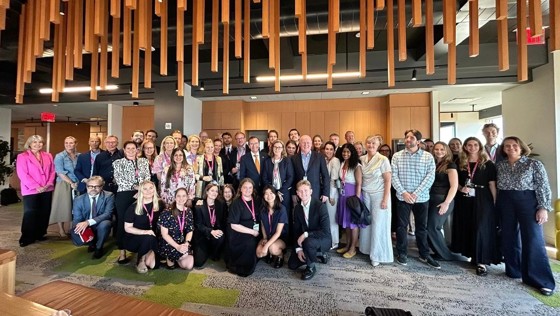 Mange mennesker på rad inne på et kontor