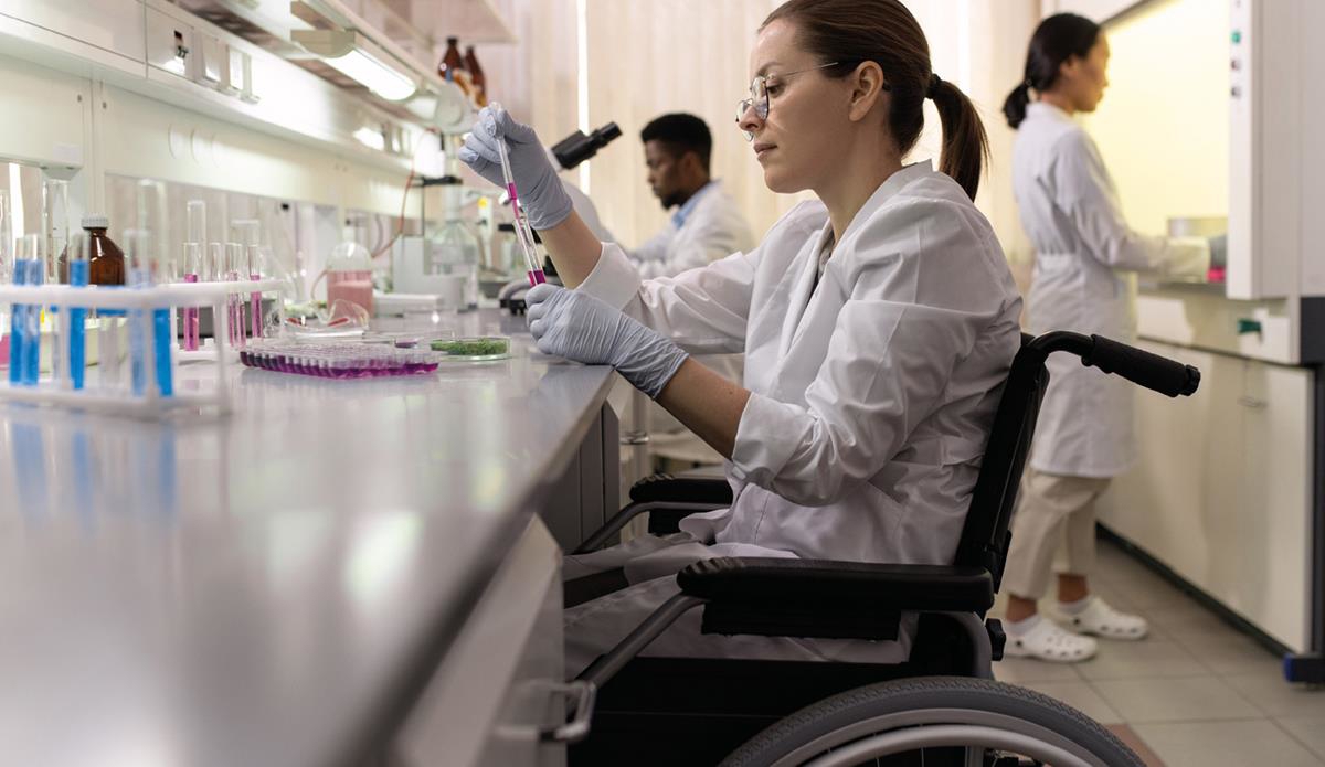 Tre mennesker i hvite frakker som arbeider i et laboratorium.