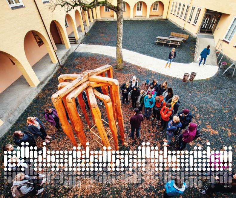 Omslagsfoto viser skoleklasse i gårdsrommet til hovedbygningen på Falstadsenteret