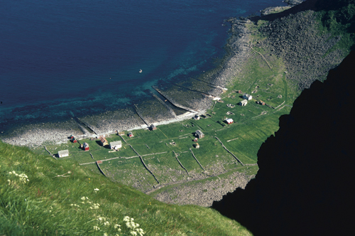 Figur 6.5 Langs store deler av norskekysten har folk vært bosatt
 på smale strandflater, med nærhet til fiskeressursene
 og samtidig litt jord til et begrenset jordbruk. Her på Værøy
 synes fortsatt de gamle driftsstrukturene godt i landskapet.