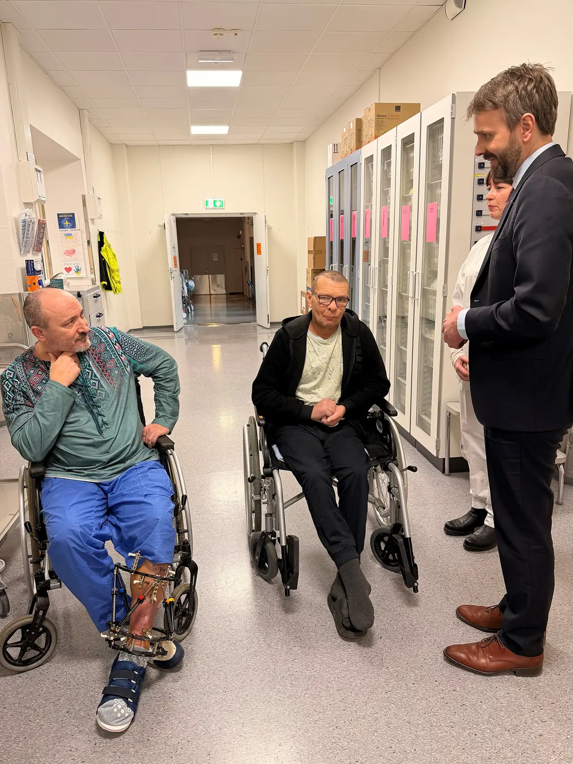 Helse- og omsorgsminister Jan Christian Vestre sammen med to Medevac-evakuerte ukrainske pasienter