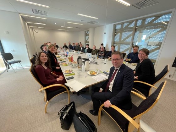 Statsråd Bjørn Arild Gram sammen med representanter fra offentlig og privat sektor rundt et stort møtebord i Steinkjer. 