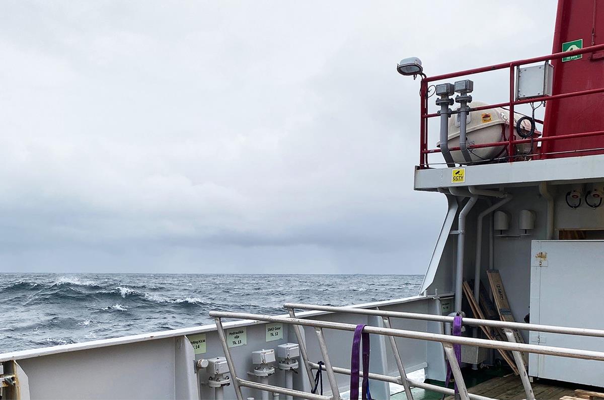 Foto viser utsnitt av dekket til H.U. Sverdrup på tokt. Havet har bølger og himmelen er overskyet.