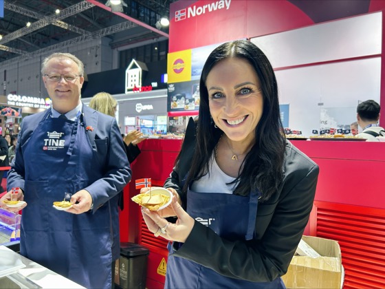 Statssekretær Brekken deler ut brunost på Norges paviljong på den store messen CIIE, i Shanghai.