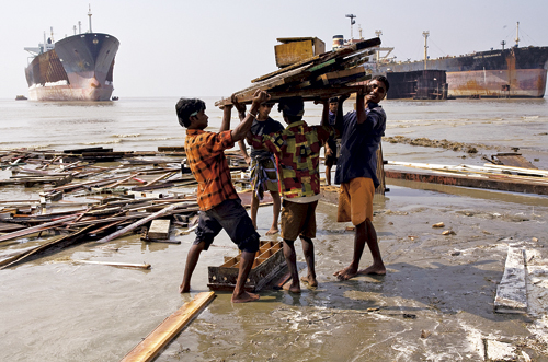 Figur 9.2 Unge gutter og menn jobber som skipsopphuggere på en
 strand i Bangladesh.