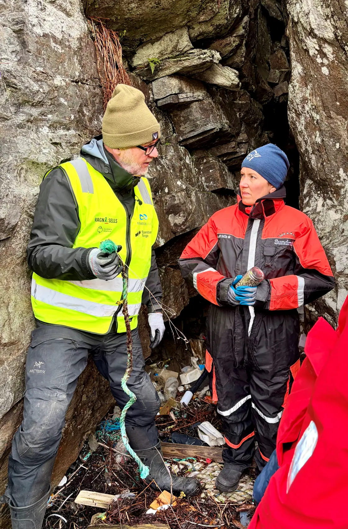 Marianne Sivertsen Næss og Kenneth Bruvik i en bergsprekk fylt med plast fra havet.