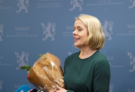 Benedicte Bjørnland med blomster etter å ha blitt gratulert av justis-, beredskaps- og innvandringsminister Tor Mikkel Wara.