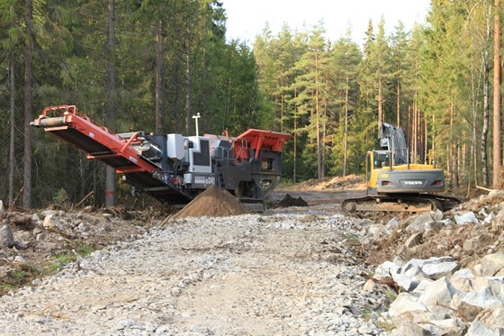 Ombygging av skogsbilveg i Åsnes. Mobilt knuseverk lager solid bærelag av kortreiste fjell- og steinmasser. 