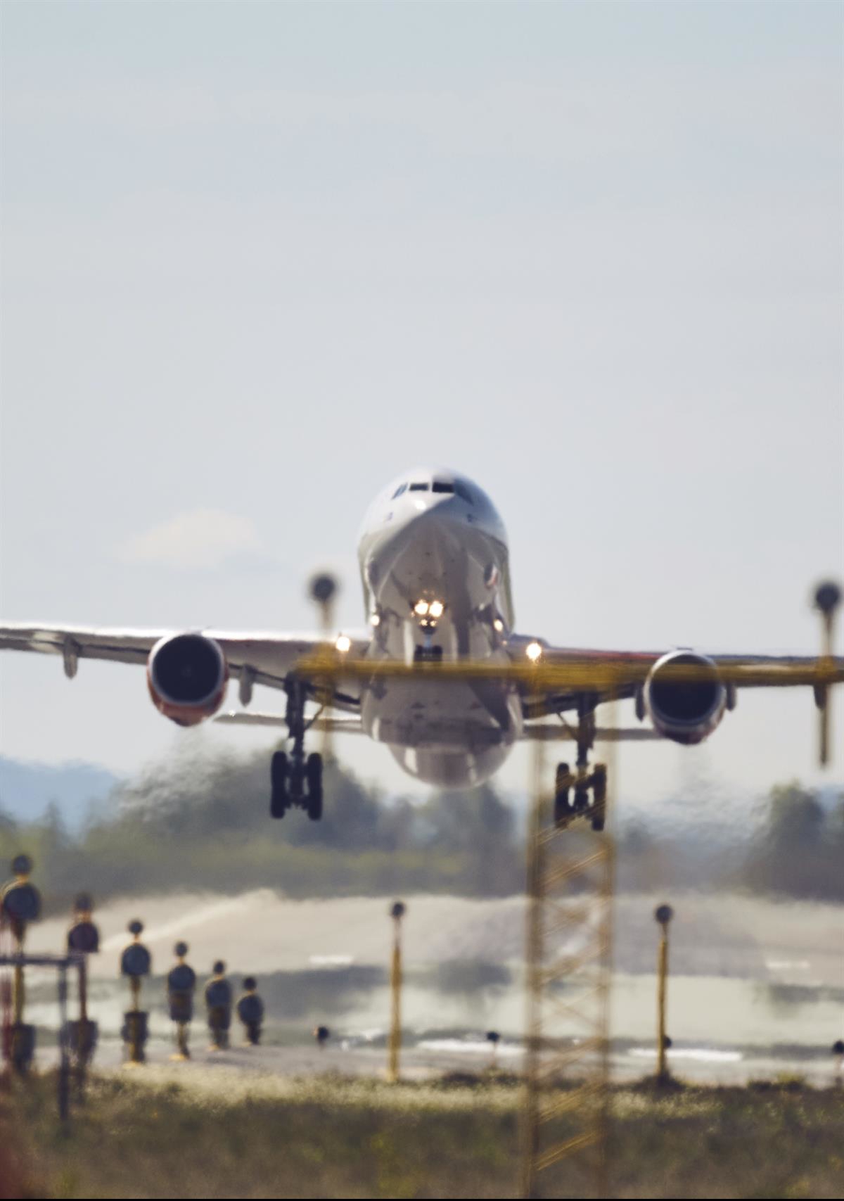 Foto av et fly som tar av fra en rullebane.