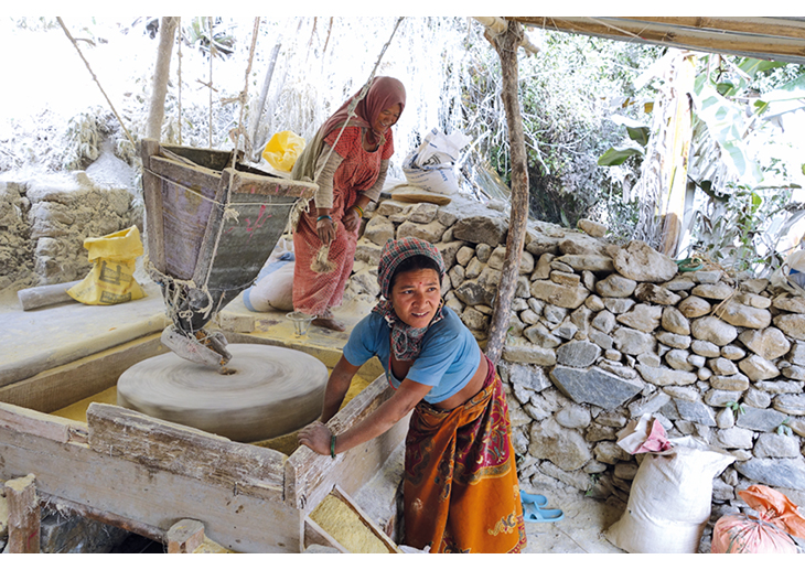 Figur 5.4 Nepal. En kvinne maler mais med kraft av vannmølle, drevet av overskuddsvann fra et mikrokraftverk finansiert av NRREP. 
