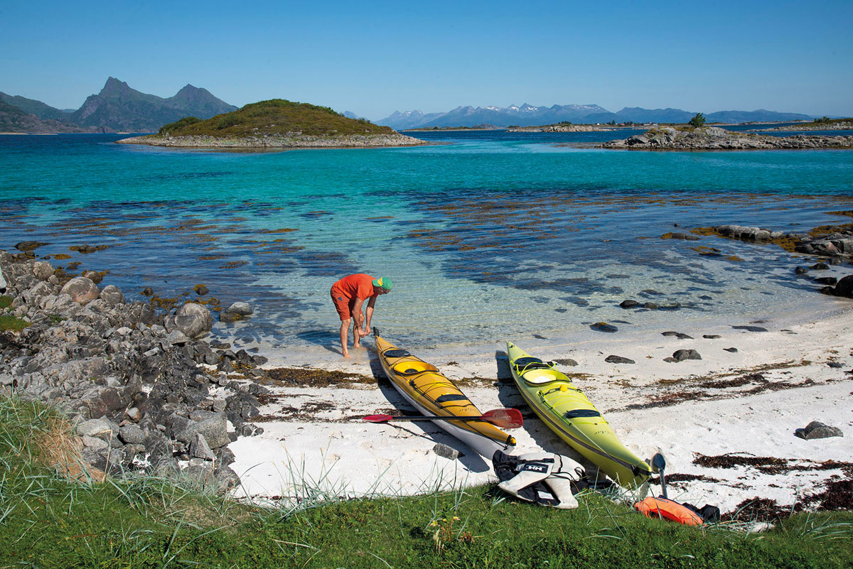 To kajakker og en mann på en sandstrand i Lofoten
