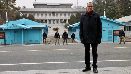 Utenriksministeren fremfor to blå hus ved grenseovergangen mellom Sør-korea og Nord - Koreaa