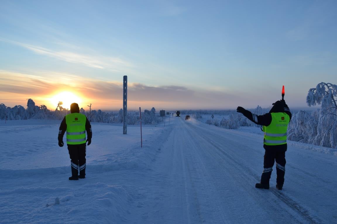 Kontrollør fra Statens vegvesen vinker inn en tungtransport til kontroll på en vintervei.