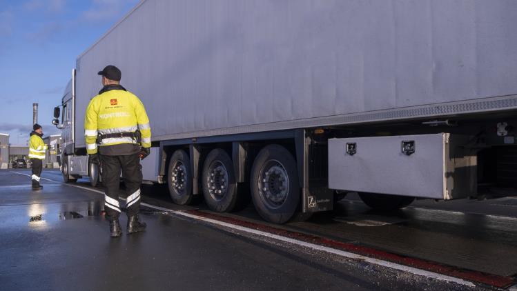 To kontrollører fra Statens vegvesen undersøker en lastebil.