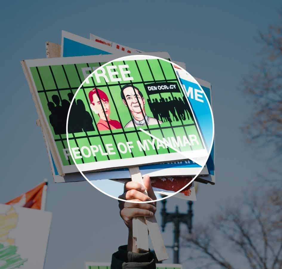 The picture illustrates protesters' resistance to the military coup in Myanmar through slogans held up in the air - caption: Free people of Myanmar.