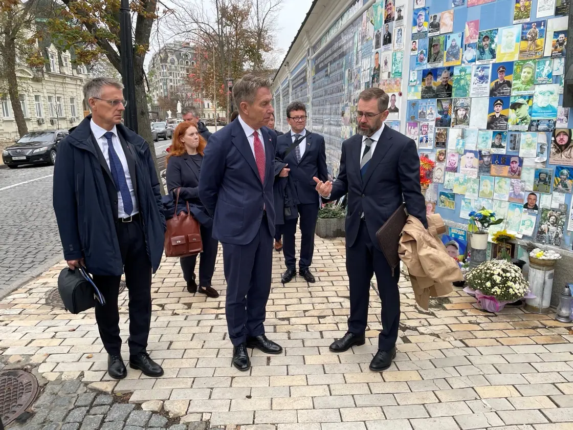 Vassdrags- og energidirektør Kjetil Lund, energiminister Terje Aasland og Norges ambassadør til Ukraina, Lars Ragnar Aalerud Hansen, foran minneveggen for de falne i Ukraina.