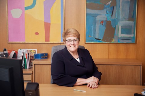 The Minister at her desk in her office.