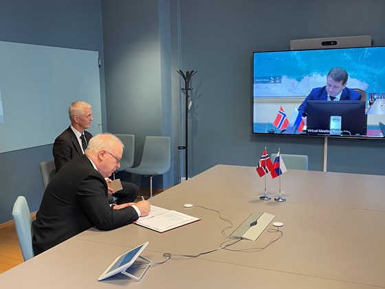 Ass. departementsråd og delegasjonsleder Morten Berg signerer avtalen for Norge.