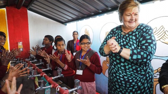 Statsministeren sammen med skolebarn på en skole utenfor New Delhi i India. Barna viser hvordan de vasker hendene.