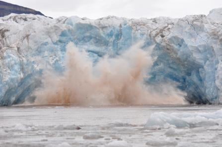 En isbre som kalver og lager en kraftig vannsprut i fjorden. Foto: Geir Wing Gabrielsen / NP