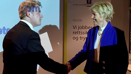 Justis- og beredskapsminister Per-Willy Amundsen mottar utredningen fra utvalgets leder, Anne Cathrine Frøstrup.