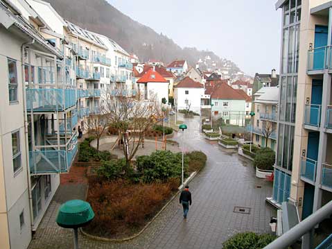 Figur 5.7 Birkebeinerkvartalet på Fjellsiden i Bergen (med 18 boliger pr. da). Åpning i bebyggelsen slipper inn sol og gir utsikt over byen. Barnehage i første etasje til venstre. Barna bruker hele gårdsrommet for lek. Under gårdsrommet og de 84 boligene er de...