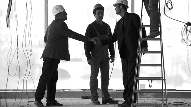 Bilde av tre menn på en byggeplass. 