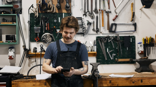 Ung gutt som står inne på et verksted