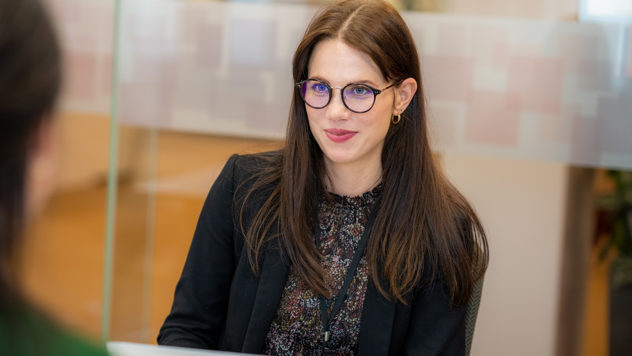 Ei kvinnleg tilsett som diskuterer med ein anna kollega