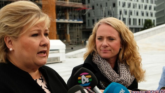 Statsminister Erna Solberg til venstre og arbeids- og sosialminister Anniken Hauglie til høyre snakker til pressen foran byggeplass i Bjørvika, Oslo.