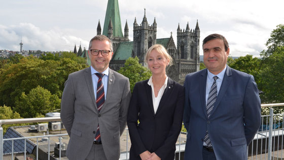 Morten Bakke (statssekretær i Arbeids- og sosialdepartementet, Trude Vollheim (direktør for Arbeidstilsynet) og Gregori Milchin (generalsekretær for det Bulgarske Arbeidstilsynet) på taket av Arbeidstilsynets lokaler i Trondheim med Nidarosdomen i bakgrunnen.