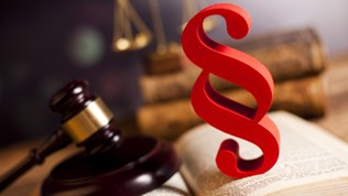 En hammer som slår mot en lovbok