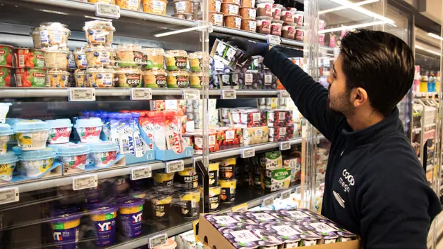 Coop-ansatt som fyller på varer