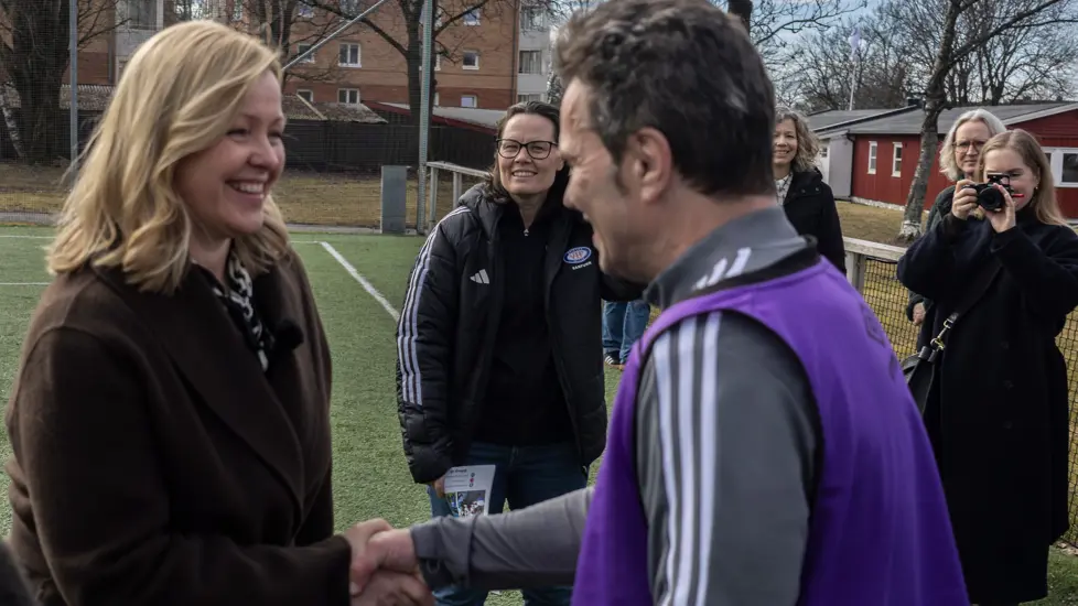 Arbeids- og inkluderingsminister Kjersti Stenseng som hilser på en av spillerene på Vålerenga Gatelag