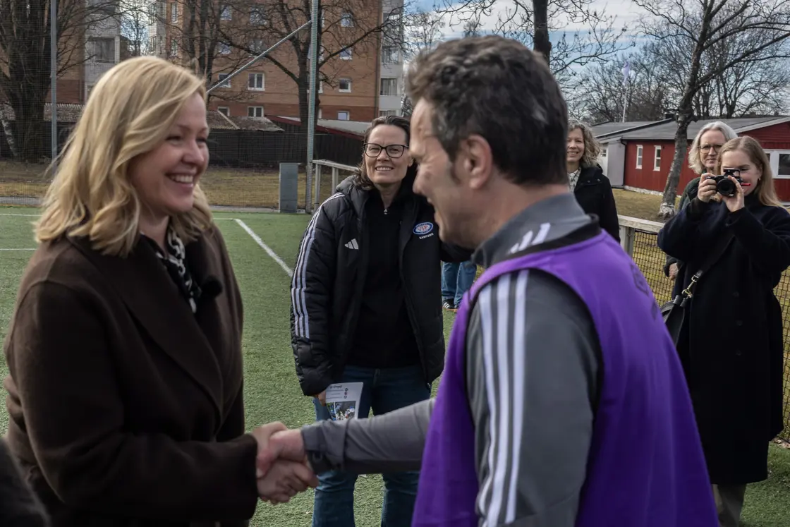 Arbeids- og inkluderingsminister Kjersti Stenseng som hilser på en av spillerene på Vålerenga Gatelag