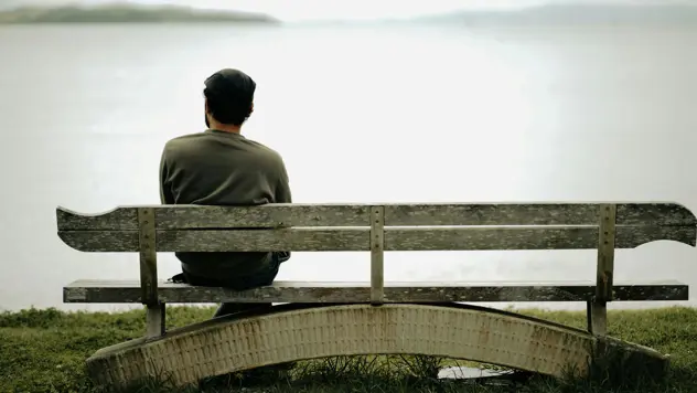 Mann som sitter på en benk.