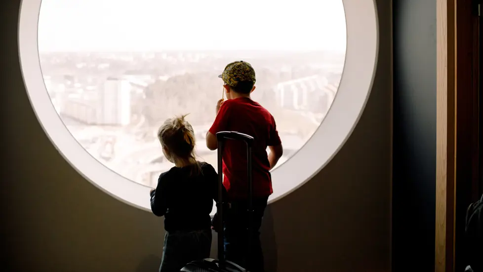 To gutter som titter ut av et stort vindu