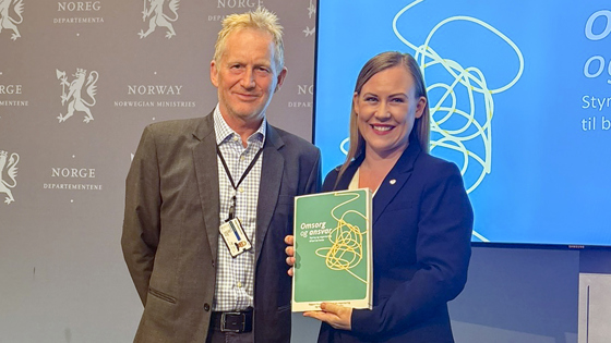 Utvalgsleder og statsråden med rapport.