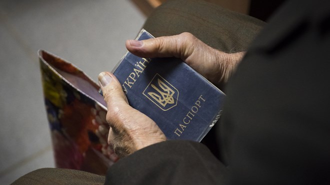 Gamle hender som holder ukrainsk pass
