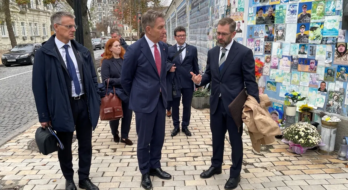 Vassdrags- og energidirektør Kjetil Lund, energiminister Terje Aasland og Norges ambassadør til Ukraina, Lars Ragnar Aalerud Hansen, foran minneveggen for de falne i Ukraina.