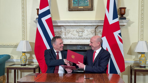 Nores og Storbritannias forsvarsministre tar hverandre i hendene etter avtalesignering.