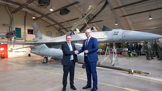 Forsvarsminister Bjørn Arild Gram gratulerer Romanias ambassadør Cristian Bădescu foran ett av tre F-16 som ble overlevert til Romania på Rygge flystasjon i dag.