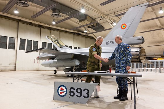 Oberst Eivind Åsmund Sørdal og major Lurgo Bildigau signerer overføringspapirer i forbindelse med Romanias kjøp av norske F-16. Demonterte ""norske skilter" i forgrunnen.