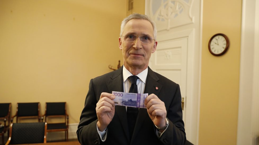 Finansminister Jens Stoltenberg holder opp en tusenlapp.
