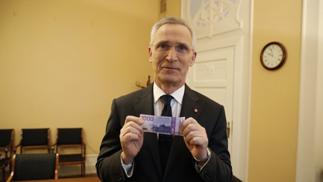 Finansminister Jens Stoltenberg holder opp en tusenlapp.