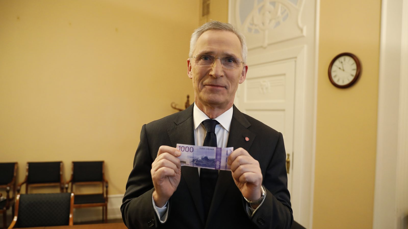 Finansminister Jens Stoltenberg holder opp en tusenlapp.