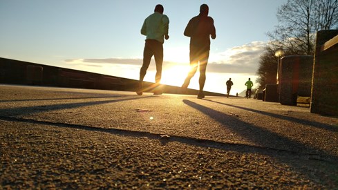 To mennesker løper i solnedgang
