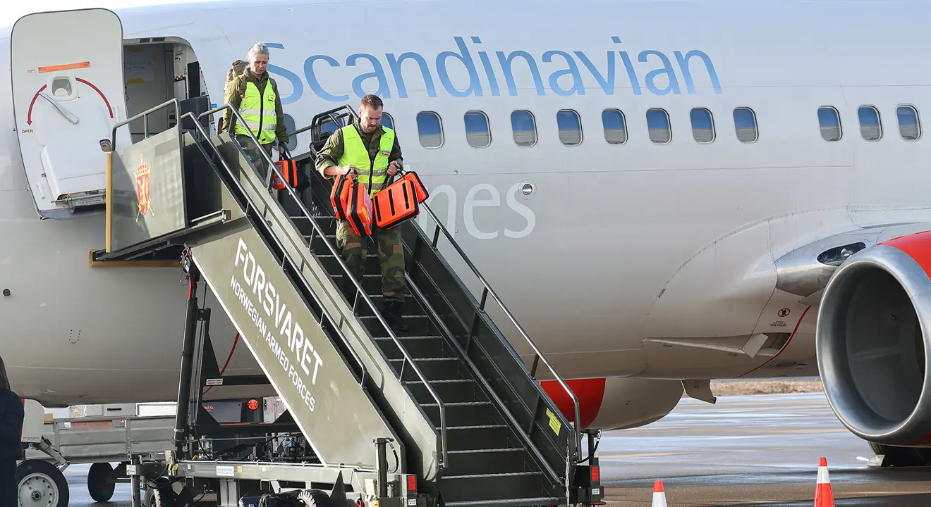 To personer går ut flytrappa fra Medevac-flyet